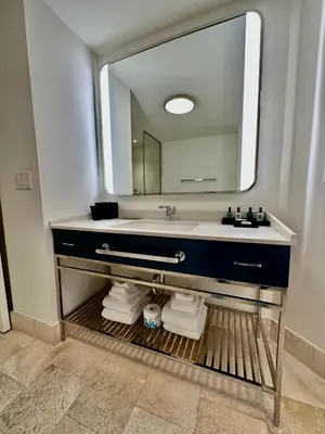 a bathroom with a sink and a large mirror at Fontainebleau Miami Beach,Tresor in Miami Beach