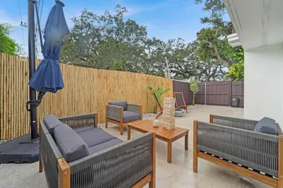 a patio with two couches and a table and an umbrella at Casa Copal: Relaxing Beach House in Hollywood