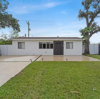 a large white house with a grass yard at Casa Copal: Relaxing Beach House in Hollywood