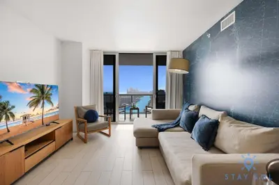 a living room with a couch and a tv at Beachwalk Resort - Pool - Gym - Amazing view in Hallandale Beach