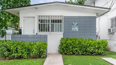 a white and gray house with a window at Brickell Pearl Cozy House Beach 10 min Location in Miami