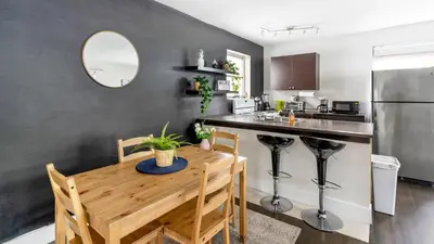 a kitchen with a wooden table and a stainless steel refrigerator at Brickell Pearl Cozy House Beach 10 min Location in Miami