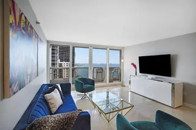 a living room with a blue couch and a television at Wildest Dreams Penthouse! Dreams Do Come True in Miami
