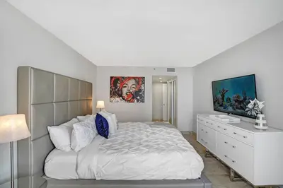 a white bedroom with a large bed and a dresser at Wildest Dreams Penthouse! Dreams Do Come True in Miami