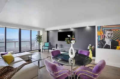 a living room with a glass table and purple chairs at The Bond - OO7 Vibes and Penthouse Water Views! in Miami