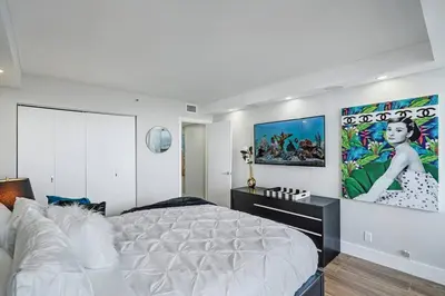 a bedroom with a large bed and a large painting on the wall at The Bond - OO7 Vibes and Penthouse Water Views! in Miami