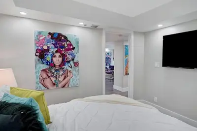 a bedroom with a painting of a woman on the wall at The Bond - OO7 Vibes and Penthouse Water Views! in Miami