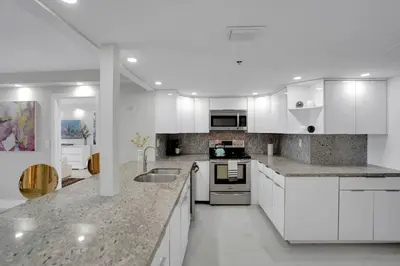 a large white kitchen with white cabinets and appliances at Superstar! Penthouse with Water and Park Views! in Miami