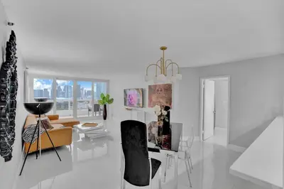 a white living room with a table and chairs at Paradise Found! Miami Skyline and Water Views! in Miami