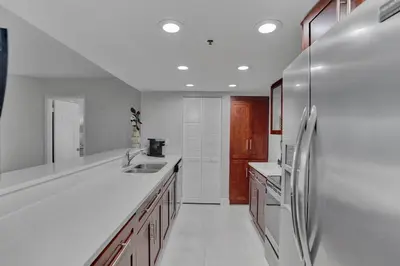 a white kitchen with a refrigerator and a sink at Paradise Found! Miami Skyline and Water Views! in Miami