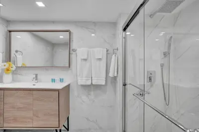 a bathroom with a shower and a sink and a mirror at Paradise Found! Miami Skyline and Water Views! in Miami