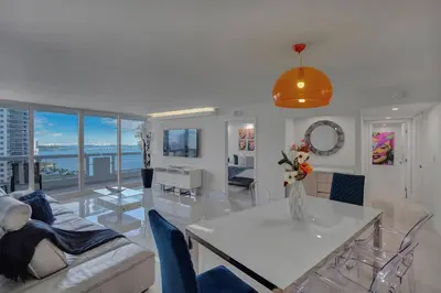 a living room with a couch and a table with chairs at Elevate! Water and Park Views in Miami