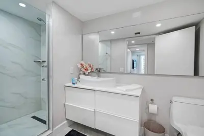 a white bathroom with a sink and a mirror at Unforgettable! Water & Park Views, 4 Bedrooms! in Miami