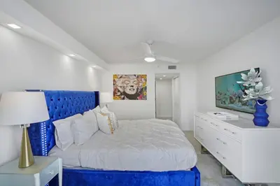 a bedroom with a blue bed and a white dresser at City of Dreams! Renovated With Water & Park Views in Miami