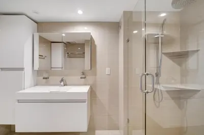 a white bathroom with a sink and a shower at Some Like It Hot! Miami Skyline & Water Views 4BR in Miami