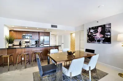 a dining room and kitchen with a table and chairs at Some Like It Hot! Miami Skyline & Water Views 4BR in Miami