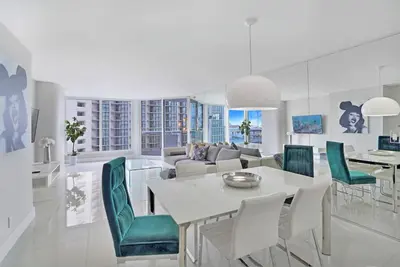 a living room with a table and green chairs at Life Is Gucci! Gorgeous WATER VIEWS Miami Condo! in Miami