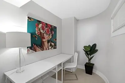 a white room with a white desk with a painting on the wall at Champagne & Ice! Water Views, 2 Private Balconies! in Miami