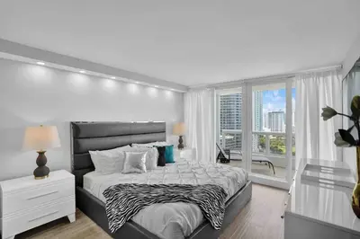 a white bedroom with a large bed and a window at Big Energy! Water Views and Newly Renovated! in Miami