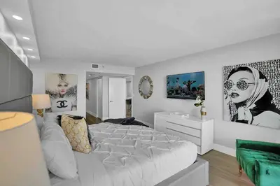 a white bedroom with a white bed and some pictures at Big Energy! Water Views and Newly Renovated! in Miami
