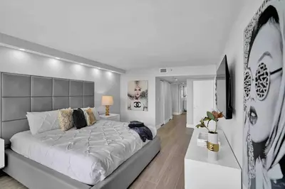 a white bedroom with a large bed and a television at Big Energy! Water Views and Newly Renovated! in Miami