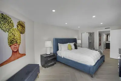 a bedroom with a bed and a painting on the wall at Visions! Water and Miami Skyline VIews! Brand New in Miami