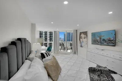 a white living room with a couch and a tv at Visions! Water and Miami Skyline VIews! Brand New in Miami