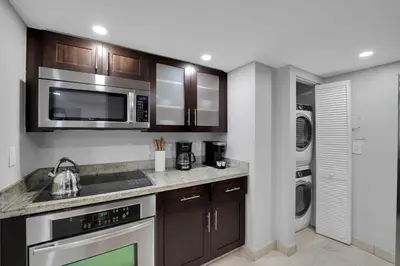 a kitchen with stainless steel appliances and a washer and dryer at Hello Gorgeous! Water & City Skyline Views! in Miami