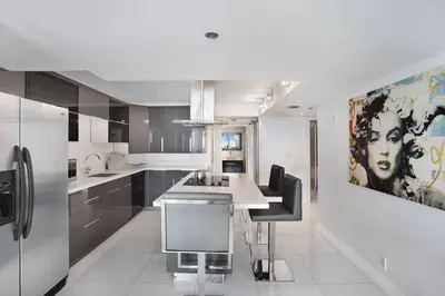a kitchen with a large painting of a woman on the wall at Spectacular! Penthouse with Direct Water Views! in Miami