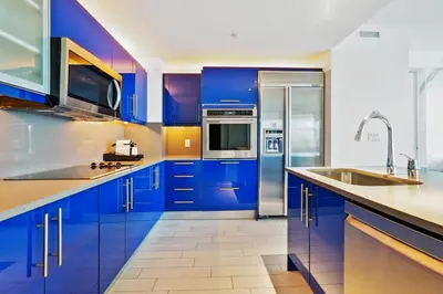 a kitchen with blue cabinets and stainless steel appliances at Oceanview Luxury, Resort Access, Sleeps 6 2BR 2BA - Vista Mar by HomeStakes Stays in Fort Lauderdale