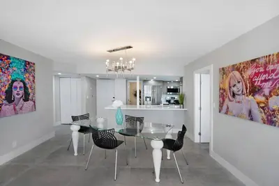 a dining room with a glass table and chairs at Blue Moon! In the lap of luxury and brand new! in Miami