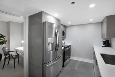 a kitchen with a stainless steel refrigerator and a table at Blue Moon! In the lap of luxury and brand new! in Miami