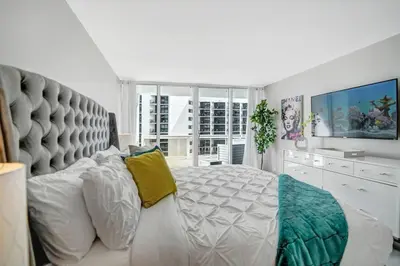 a bedroom with a large white bed with a large headboard at Blue Moon! In the lap of luxury and brand new! in Miami
