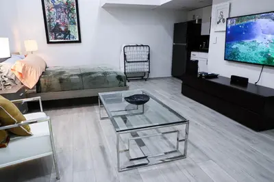 a living room with a tv and a glass table at VILLA GUILLA in Miami