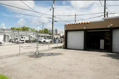 a building with a garage with cars parked in a parking lot at Homey Little Havana Apt Centrally located Hv4 in Miami