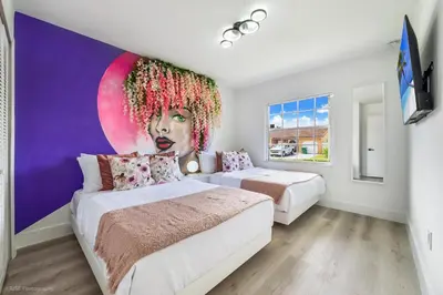 a bedroom with two beds and a painting of a woman at Flamingo's Resort -Htd Pool, 5 Bedrooms, Game Room, Baby Items , BBQ in Miami
