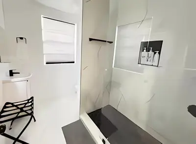 a white bathroom with a shower and a chair at Gorgeous Private Room, near the Airport - Free parking - 02 in Miami