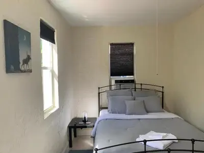 a bedroom with a bed and a table and two windows at Cute Private Room, near the Airport - Free parking - 02 in Miami