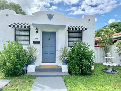 a white house with a blue door at Cute Private Room, near the Airport - Free parking - 02 in Miami