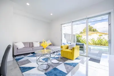 a living room with a yellow chair and a glass table at Modern 4-Bedroom Townhouse with Pool! in Miami
