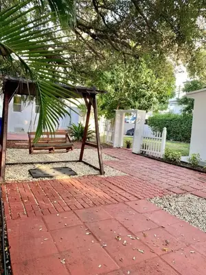 a swing on a brick patio with a bench at Cozy Private House near Miami Airport - Free parking - 02 in Miami