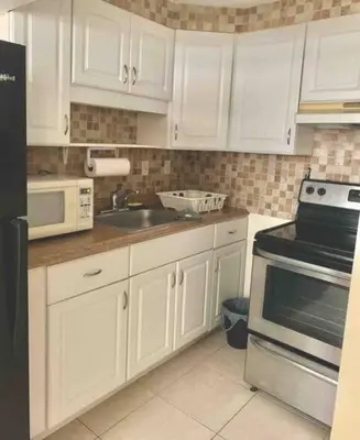 a kitchen with white cabinets and a sink at Cozy Private House near Miami Airport - Free parking - 02 in Miami