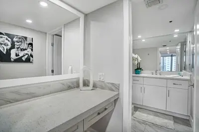 a white bathroom with a sink and a mirror at Miami Vice! Totally Renovated, Water & Park Views! in Miami