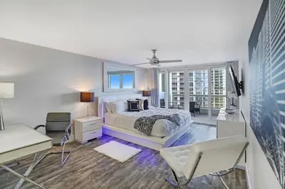 a white bedroom with a bed and a desk and chair at Miami Vice! Totally Renovated, Water & Park Views! in Miami