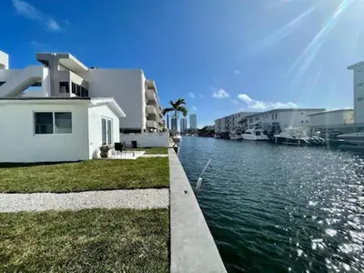 a house next to a body of water with buildings at Casa Canal in North Miami Beach