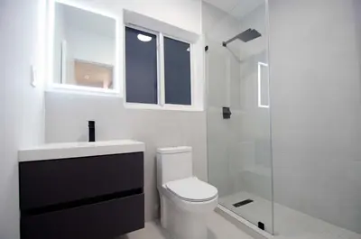 a bathroom with a toilet and a glass shower at Casa Canal in North Miami Beach