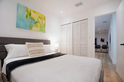 a bedroom with a large bed and a large window at Casa Canal in North Miami Beach