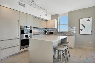 a kitchen with a counter and two stools at High Floor with Stunning View Pools Near Beach in Hollywood