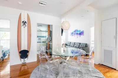 a dining room with a glass table and a surfboard at Blue Ocean Vacation Home 2 in Fort Lauderdale