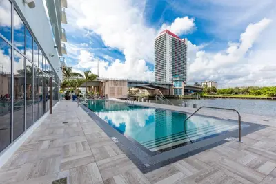 a pool on the side of a building with a tall building at 23rd-Floor Views • Pool Gym Beach Service in Hollywood